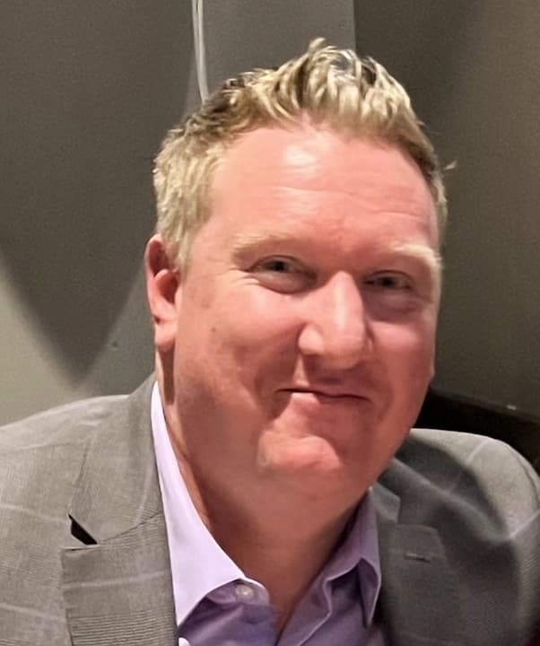 Austin smiling in a suit