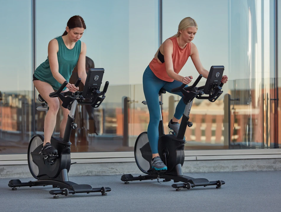 2 women using Octane exercise bike